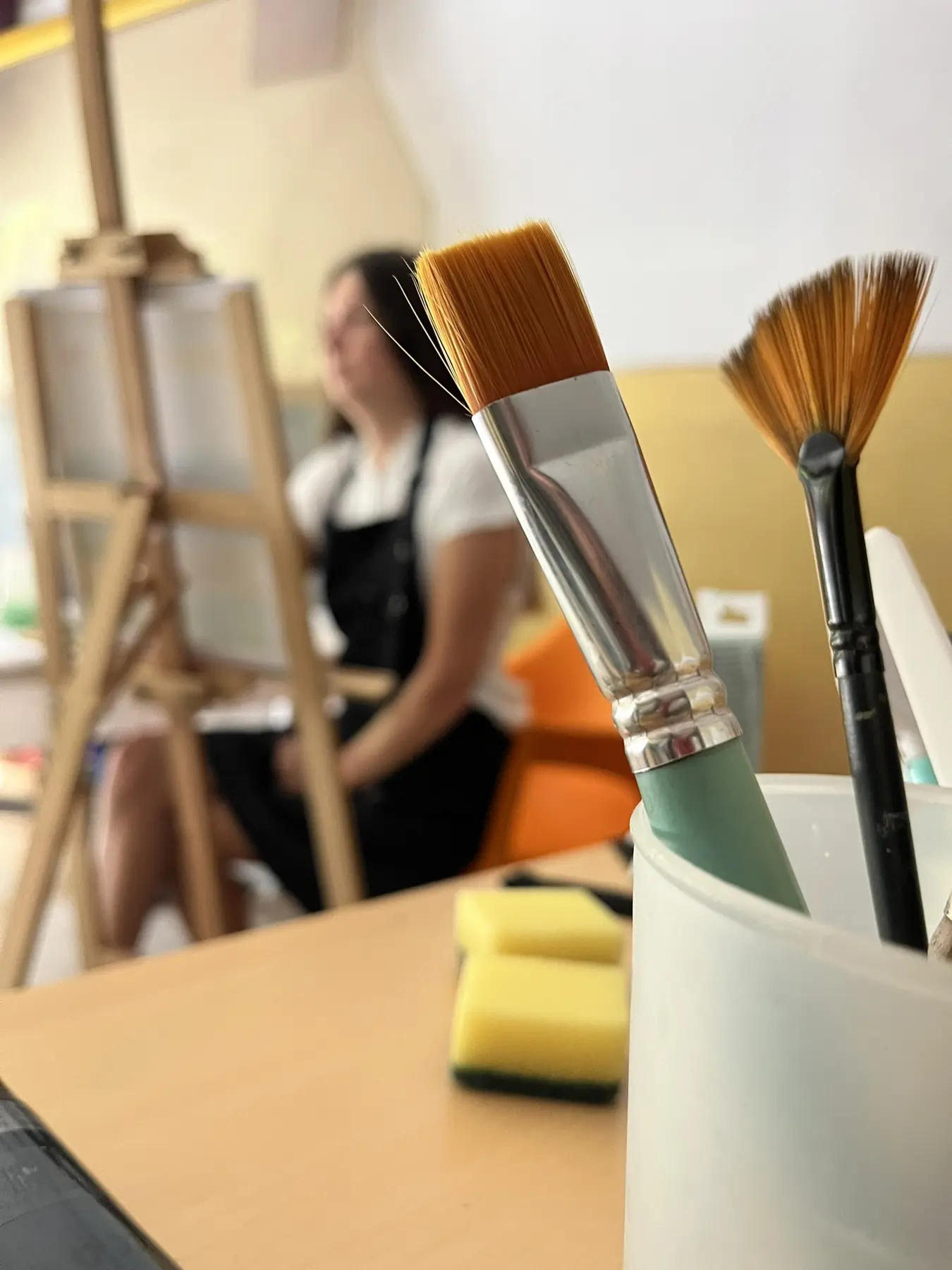 Paintbrushes in the foreground during an art therapy class